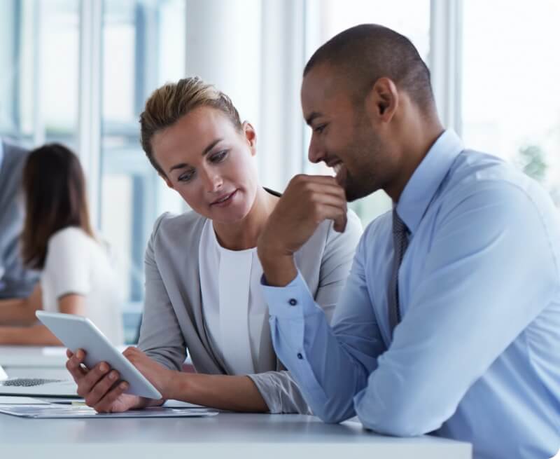coworkers going over information on mobile tablet